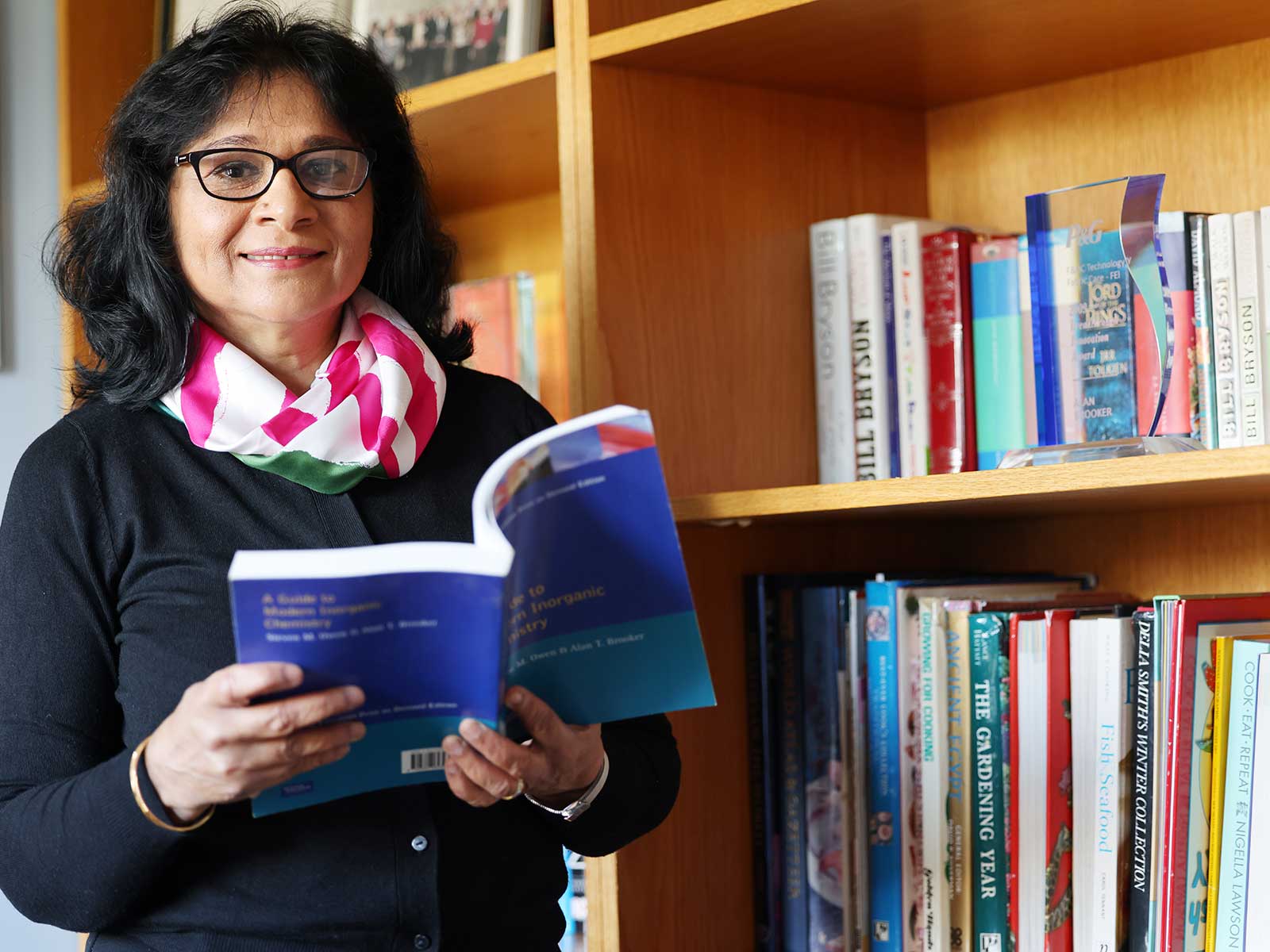 Anju Massey Brooker standing near library shelf of books